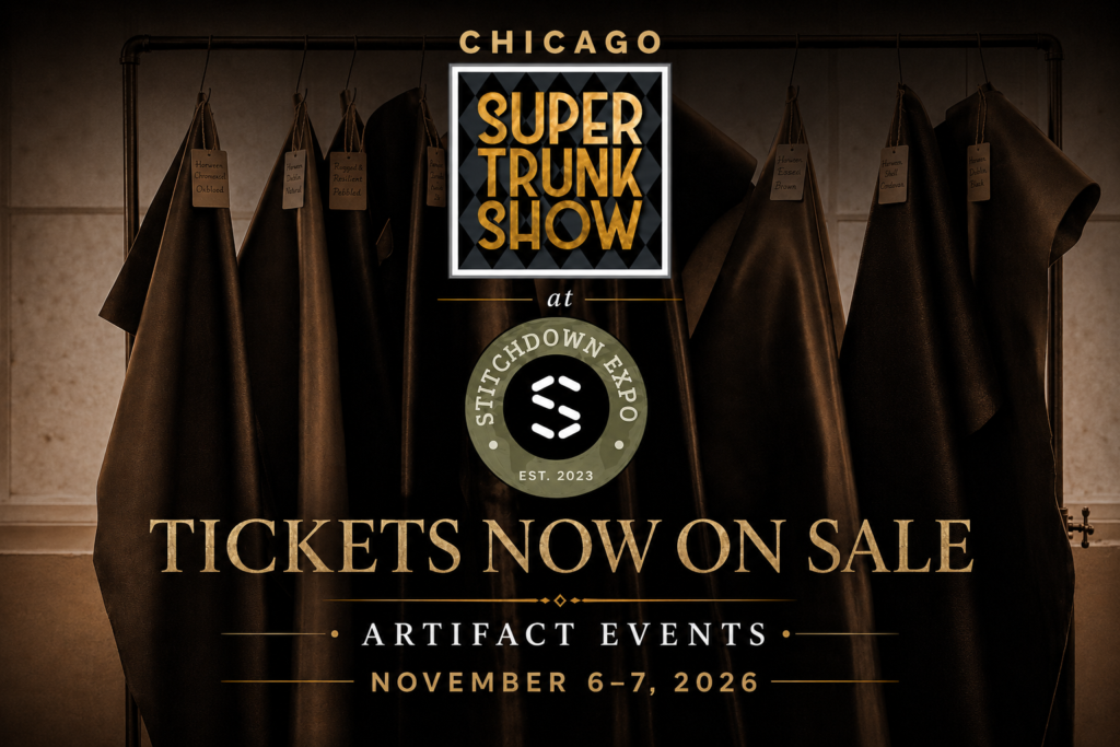 A collection of dark leather pieces hangs from a rack, each labeled with different colors and textures, promoting the Super Trunk Show at Stitchdown Expo.